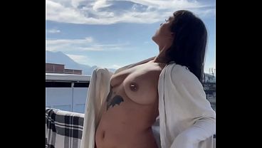 Mostrando meus peitos na varanda no limite do flagra. 
