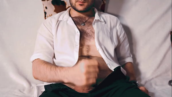 Handsome Noel Dero watches porn and caresses his dick in a condom close-up. 